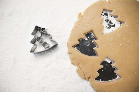 christmas gingerbread tree cookies with cutter , dough and rolling pin, full frameの写真素材