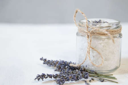 Natural herbal sea salt with aromatic lavender - perfect for relaxation. Cosmetic jars and bottles with salt, lavender flowersの写真素材
