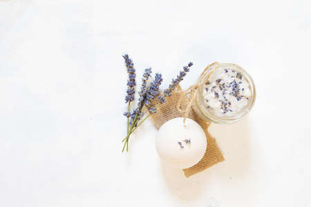 Natural herbal sea salt with aromatic lavender - perfect for relaxation. Cosmetic jars and bottles with salt, lavender flowers, bath bombの写真素材