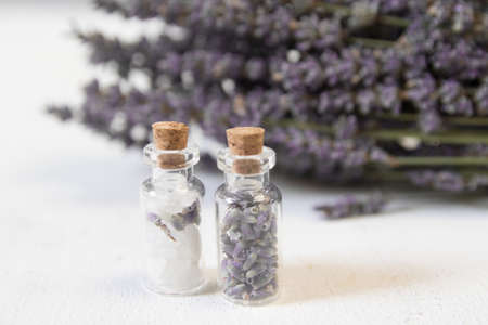 Natural herbal sea salt with aromatic lavender - perfect for relaxation. Cosmetic jars and bottles with salt, lavender flowers, bath bombの写真素材