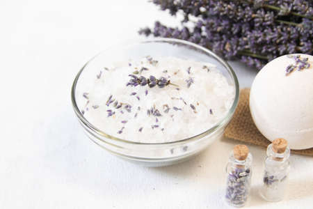 Natural herbal sea salt with aromatic lavender - perfect for relaxation. Cosmetic jars and bottles with salt, lavender flowers, bath bombの写真素材