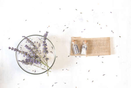 Natural herbal sea salt with aromatic lavender - perfect for relaxation. Cosmetic jars and bottles with salt, lavender flowers, bath bombの写真素材