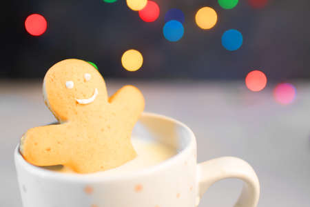 Gingerbread cookie men in a hot cup of cappuccino