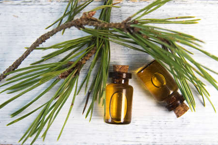 Pine essential oil and glass drops on white backgroundの写真素材