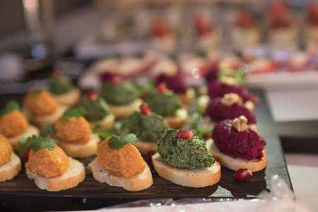 Beautifully decorated catering banquet table with different food snacks and appetizers on corporate...