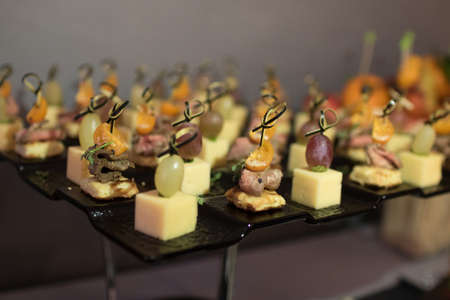 Beautifully decorated catering banquet table with different food snacks and appetizers on corporate...