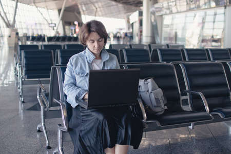 young woman using laptop computer at airport