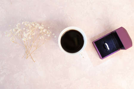 Valentines day romantic dinner table setting marry me wedding engagement ring in box with lavender gift cup of coffee surprise on pink background with copyspaceの写真素材