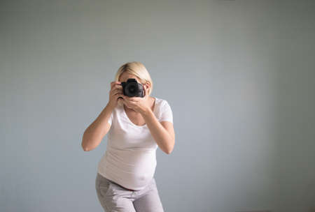 pregnant woman photographer with a film cameraの写真素材