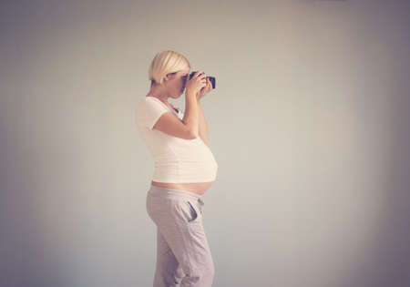 pregnant woman photographer with a film cameraの写真素材