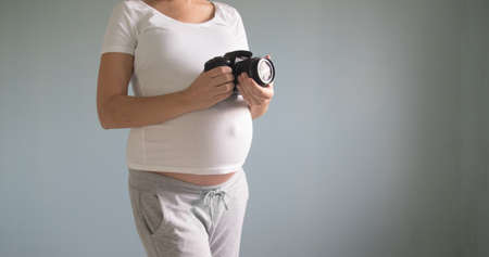 pregnant woman photographer with a film cameraの写真素材