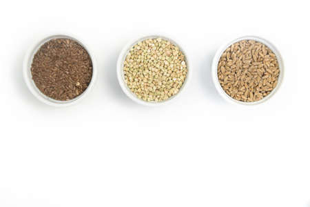 Collection of different groats on white background. Top view of buckwheat, chia, flax, amaranth, lentils, couscous, wheatの写真素材