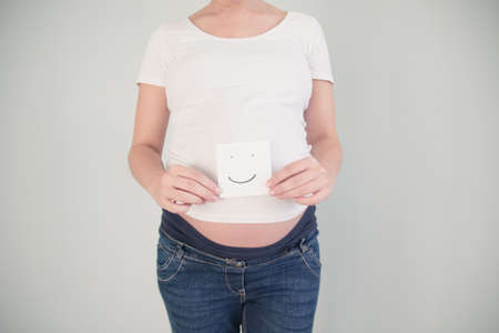 Pregnant belly painted as a faceの写真素材