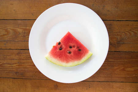 Pieces of watermelon in bowl and slice on white plate. Top view. Summer timeの写真素材