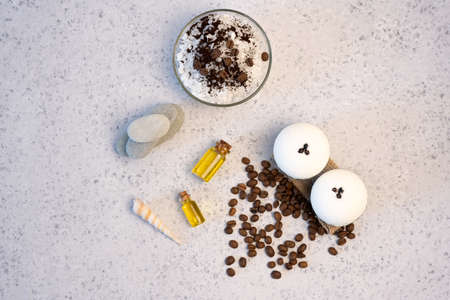 Aromatherapy and spa concept. Spa salt with coffee scent near soap, spa oil and loofah on white...