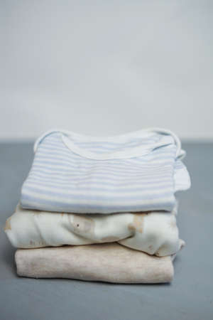 Colorful cotton folded clothes stack on white table empty space background,baby laundry.の写真素材