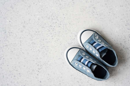 baby boy blue sneakers on grey backgroundの写真素材