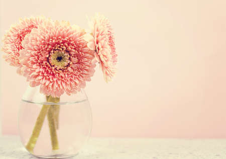 Beautiful spring pink flowers on blue pastel table in a vase. Floral borderの写真素材