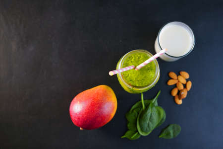 Healthy Green Reach Vitamins Smoothie with baby leaf spinach, mango, almond milk and strawberryの写真素材
