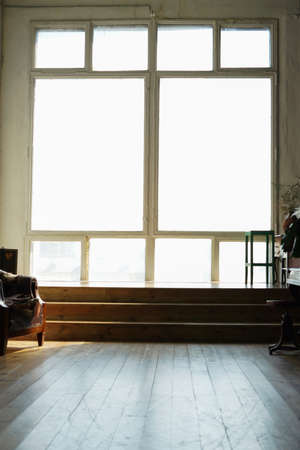 Large black metal-plastic window on the wall. From the window the sun shines brightly. Spring or...