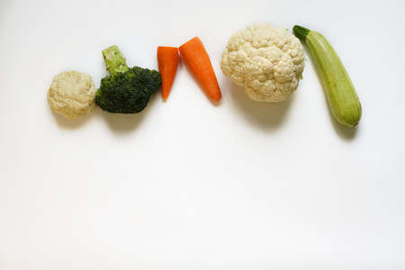 a row of vegetables - broccoli, zucchini, carrots and cauliflower as the first baby foodの写真素材