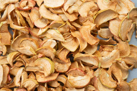 Dried apple slices in a handmade bowl and fresh apples