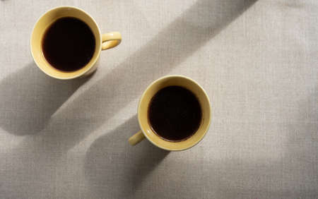 background of two cups with shadowas and sunlights. Linen backroundの写真素材