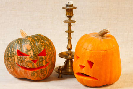 The sad and cheerful halloween pumpkin with candle from canvas backgroundの写真素材