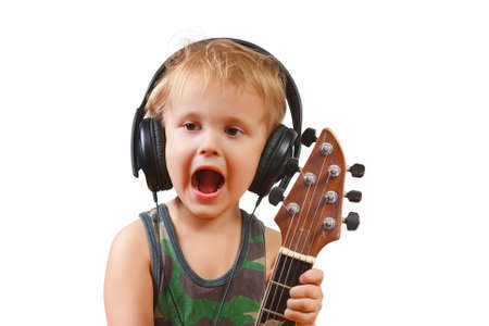 Little boy with headphones and guitar on white backgroundの写真素材