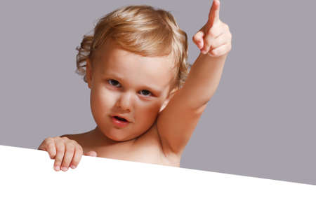 Little cute boy holding a white blankの写真素材