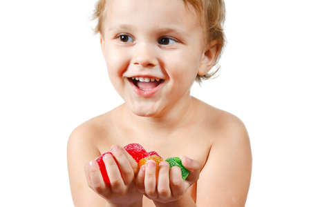 Little boy with colored jelly candies on white backgroundの写真素材