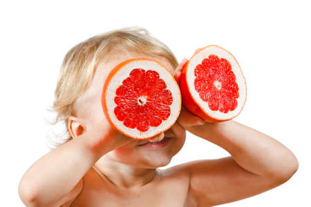 Little boy with a pink grapefruit on a white backgroundの写真素材