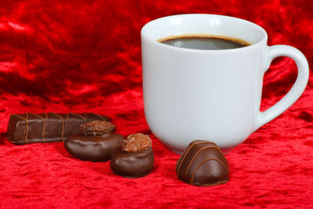 Still life of chocolate candy and coffee on a red velvetの写真素材