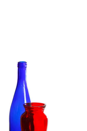 Blue glass bottle and red vase on a white backgroundの写真素材