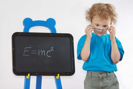 Little amazed boy with glasses shows Einstein