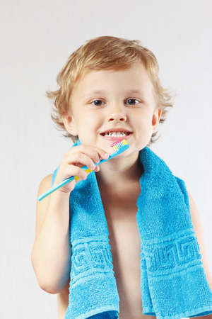 Little boy with toothbrush with pink toothpaste on a white backgroundの写真素材