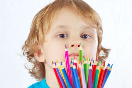 Little cute boy with color pencils on a white backgroundの写真素材