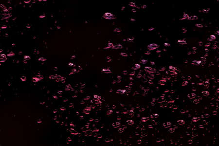 Background of garnet colors bubbles in the water on a black 