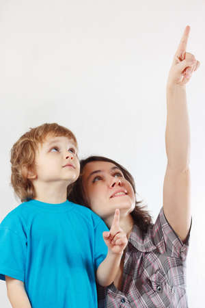 Mother shows his hand up to her little son on a white backgroundの写真素材