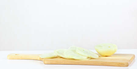 Fresh sliced raw onion on a wooden cutting board closeupの写真素材
