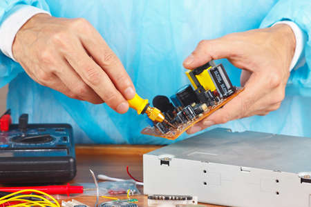 Master parses electronic hardware for repair in the service workshop