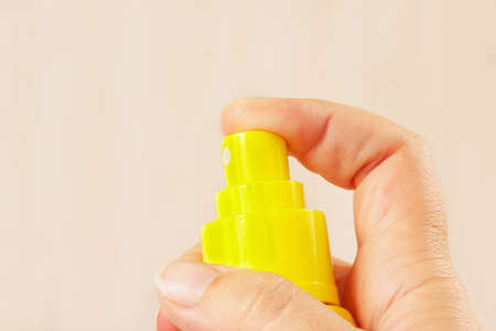 Female hand with a yellow balloon of aerosol close upの写真素材