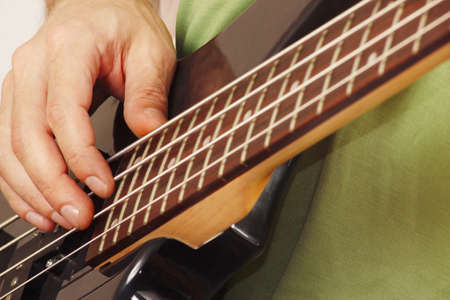 Hands of rock guitarist playing the electric bass guitarの写真素材