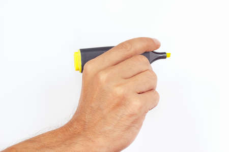 Hand holding a yellow marker on a white backgroundの写真素材