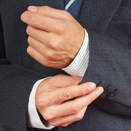 Man fastened the buttons on sleeve business suit close up