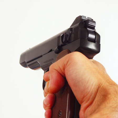 Hand with a army semi-automatic pistol close up