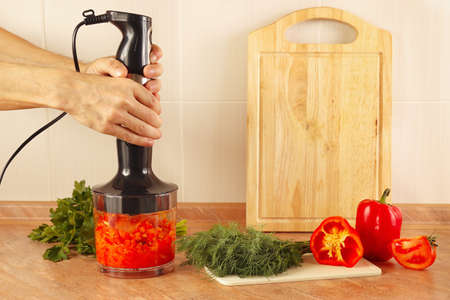 Hands chefs mixed red pepper and tomato in a blenderの写真素材