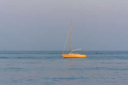 The yacht drifting in the sea at sunsetの写真素材