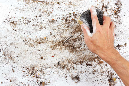 Hand with wet sponge wiping a very dirty surfaceの写真素材