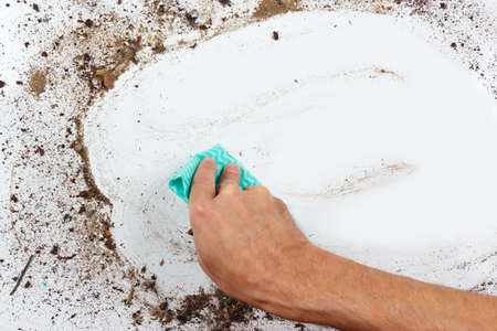 Hand with cloth cleans a dirty surfaceの写真素材